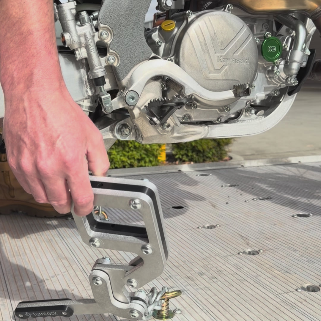 TurnLock Moto Peg Binders securing a dirt bike by the footpegs